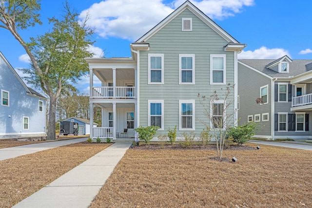 traditional home featuring a balcony and covered porch