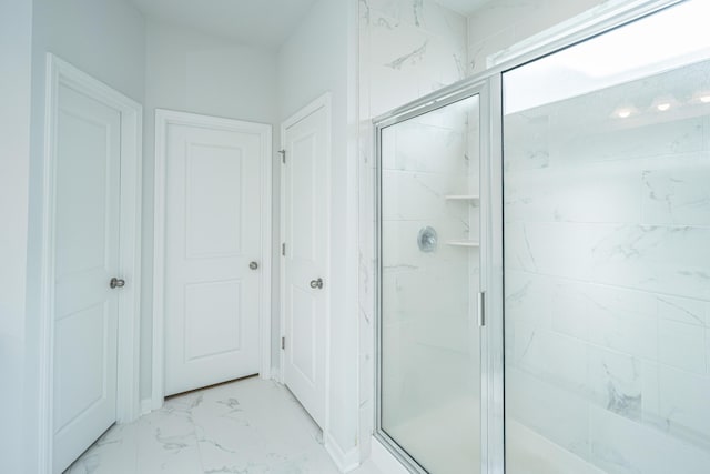 full bathroom featuring marble finish floor and a stall shower