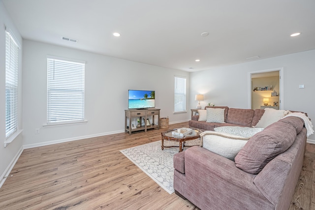 living room featuring light wood-type flooring, visible vents, baseboards, and recessed lighting