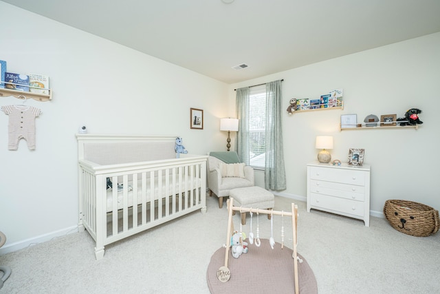 bedroom with a nursery area, baseboards, visible vents, and carpet flooring