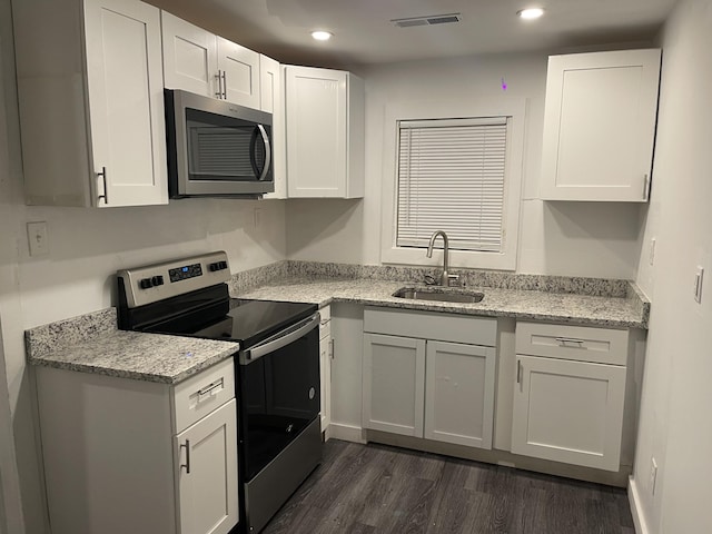 kitchen featuring dark wood-type flooring, sink, light stone counters, stainless steel appliances, and white cabinets