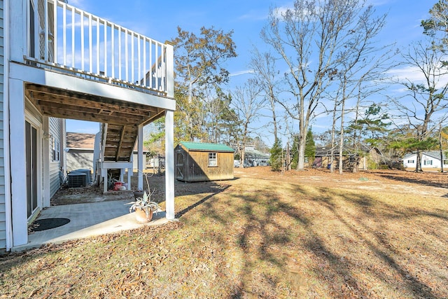 view of yard featuring a patio, cooling unit, a storage shed, and a wooden deck