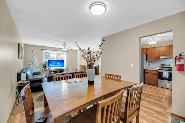 dining area with light hardwood / wood-style flooring and a textured ceiling