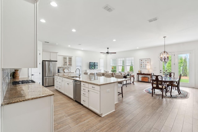 516 Tidewater Chase Ln, Summerville, SC 29486 - kitchen featuring stainless steel appliances, a breakfast bar area, light wood-type flooring, recessed lighting, and white cabinets