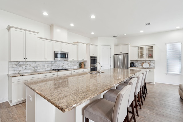516 Tidewater Chase Ln, Summerville, SC 29486 - kitchen featuring appliances with stainless steel finishes, decorative backsplash, a breakfast bar area, light wood-type flooring, and a spacious island