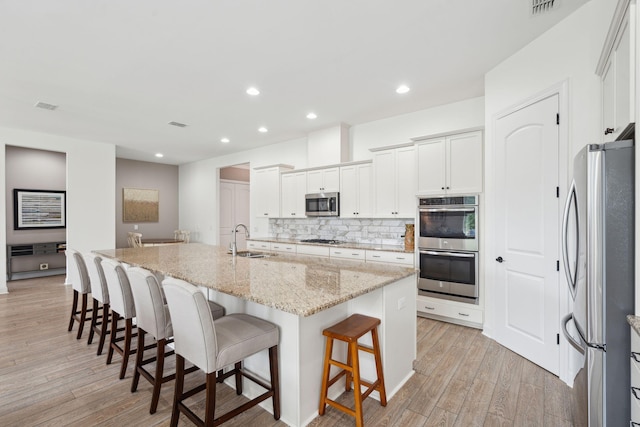 516 Tidewater Chase Ln, Summerville, SC 29486 - kitchen featuring appliances with stainless steel finishes, a sink, tasteful backsplash, light wood-style flooring, and a breakfast bar