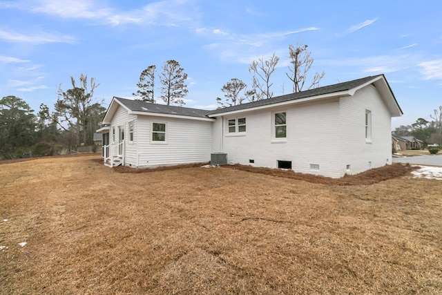 rear view of house featuring a yard and central air condition unit