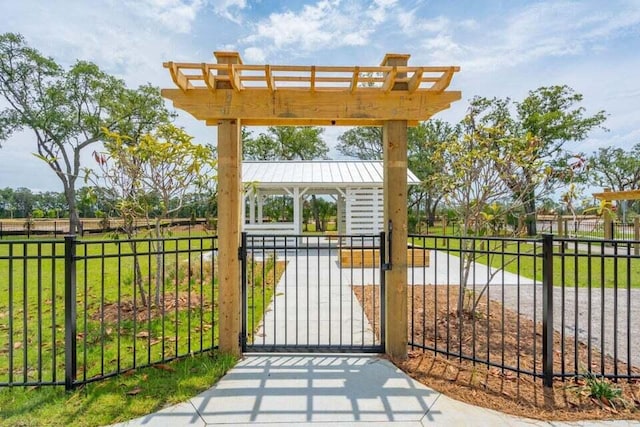 view of gate featuring a lawn and fence