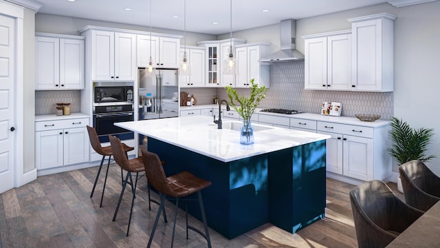 kitchen with dark wood finished floors, stainless steel appliances, wall chimney exhaust hood, decorative backsplash, and a kitchen bar
