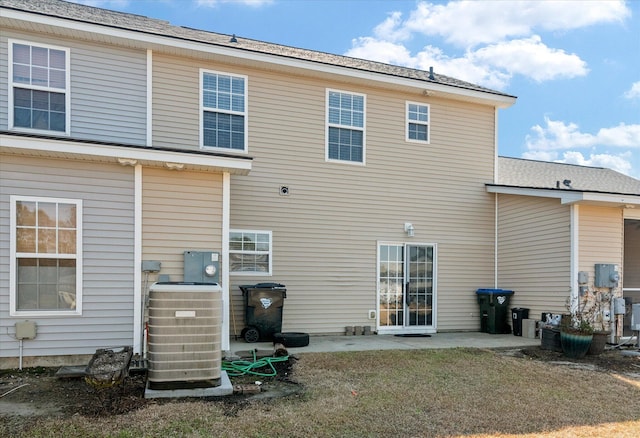 back of property with central air condition unit and a patio