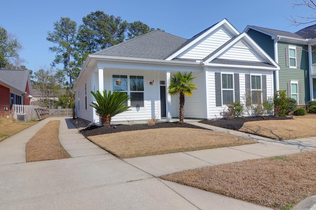 view of front of home featuring concrete driveway, roof with shingles, and fence