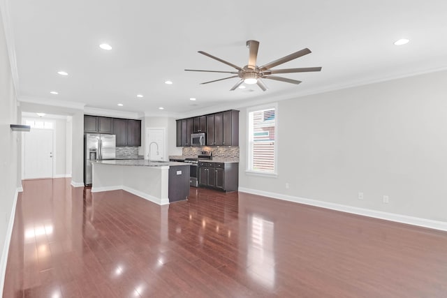 kitchen with tasteful backsplash, crown molding, appliances with stainless steel finishes, and a sink