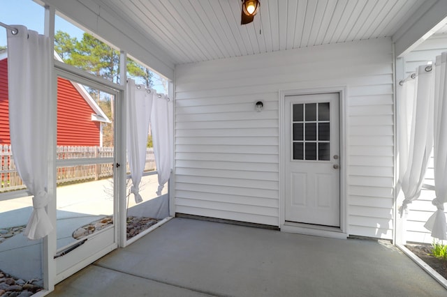 unfurnished sunroom with ceiling fan