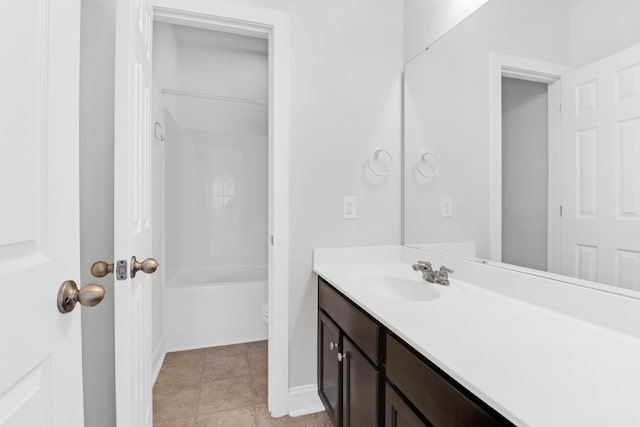 bathroom with baseboards, toilet, tile patterned flooring, vanity, and washtub / shower combination