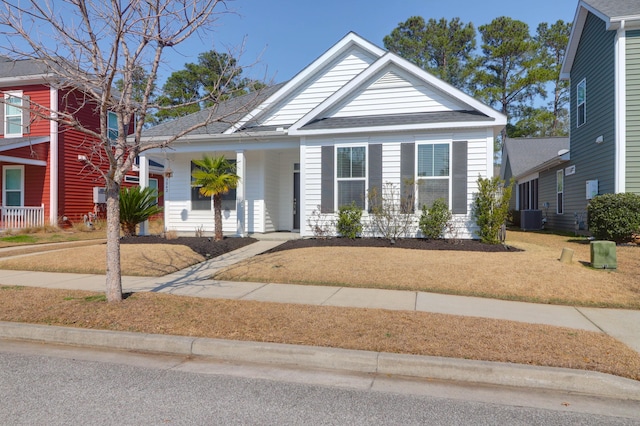 view of front of house featuring covered porch, a front yard, and central air condition unit