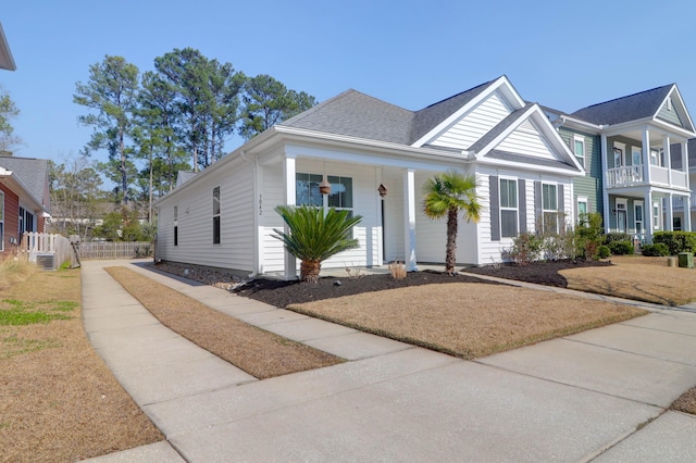 view of front facade with fence and roof with shingles