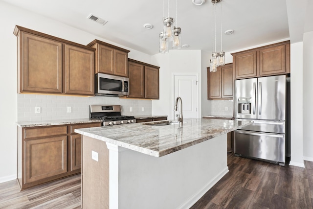 kitchen with appliances with stainless steel finishes, dark wood-style flooring, visible vents, and a sink