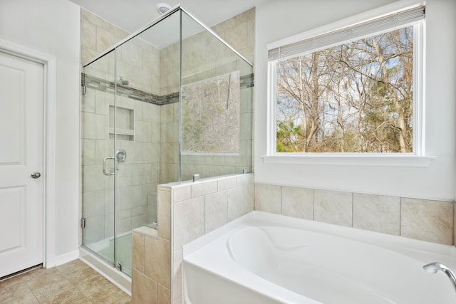 full bathroom featuring tile patterned flooring, a garden tub, and a shower stall