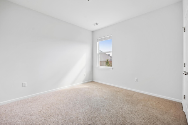 unfurnished room with light carpet, visible vents, and baseboards