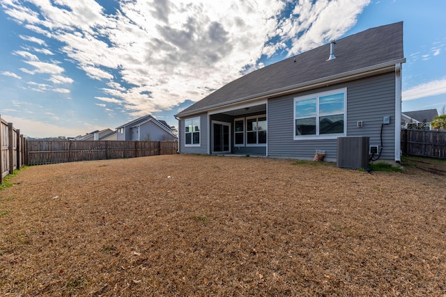 back of house featuring a fenced backyard, cooling unit, and a yard