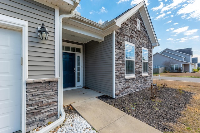 entrance to property with a garage and stone siding