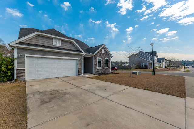 view of front of home with an attached garage, stone siding, and concrete driveway