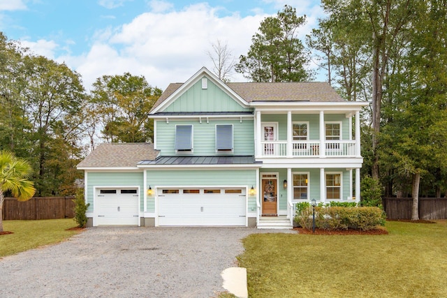 view of front of home featuring a front yard, a balcony, a garage, and covered porch