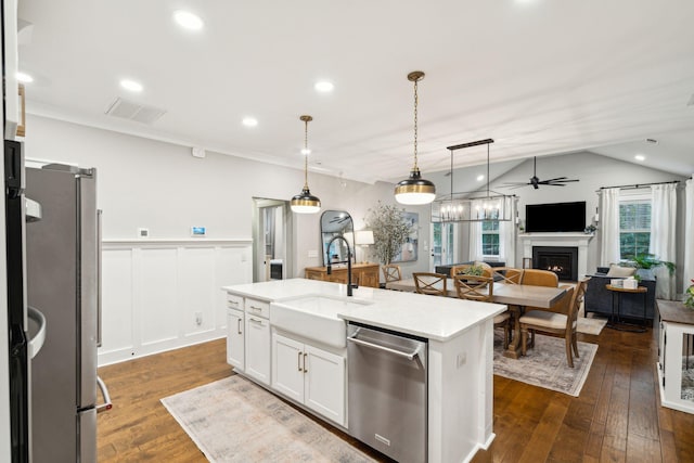 kitchen with a center island with sink, sink, ceiling fan, appliances with stainless steel finishes, and white cabinetry