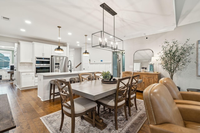 dining room with dark hardwood / wood-style floors and an inviting chandelier