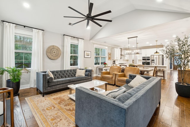 living room with wood-type flooring, ceiling fan, lofted ceiling, and a healthy amount of sunlight