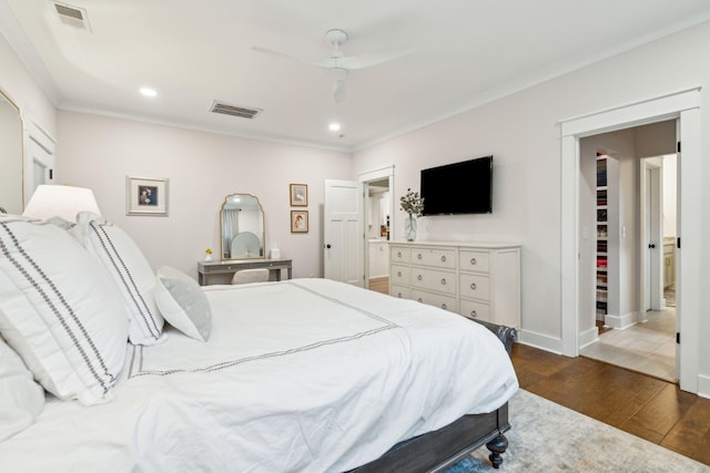 bedroom with ceiling fan, dark hardwood / wood-style flooring, a spacious closet, and ornamental molding