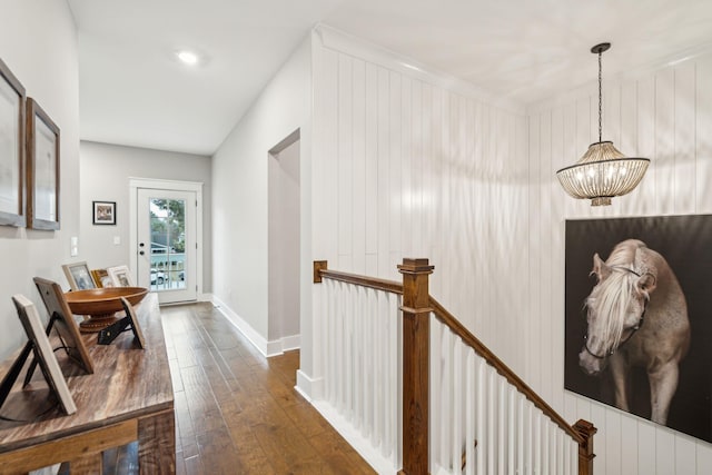 hallway featuring dark wood-type flooring and a chandelier