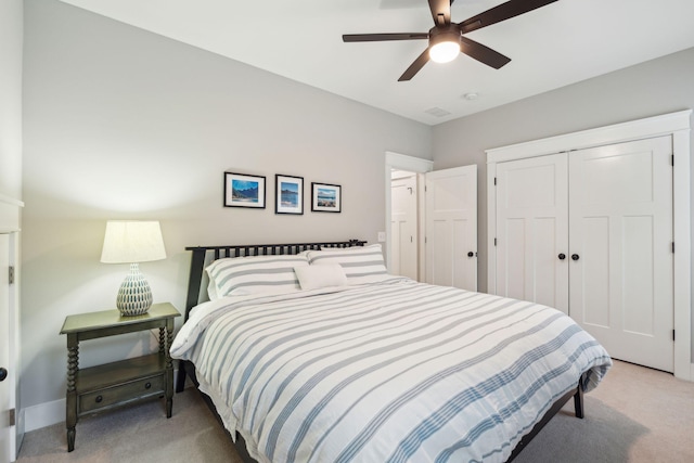 bedroom featuring ceiling fan, light carpet, and a closet