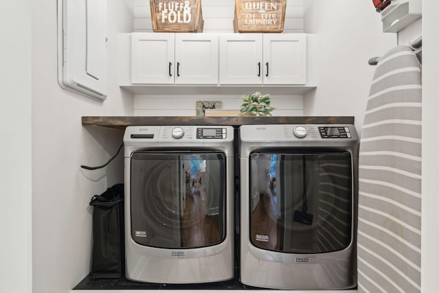 clothes washing area featuring cabinets and washing machine and dryer