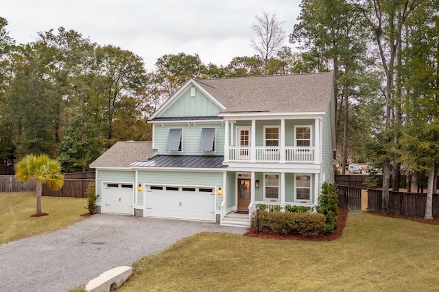 view of front facade with a balcony, a front yard, and a garage