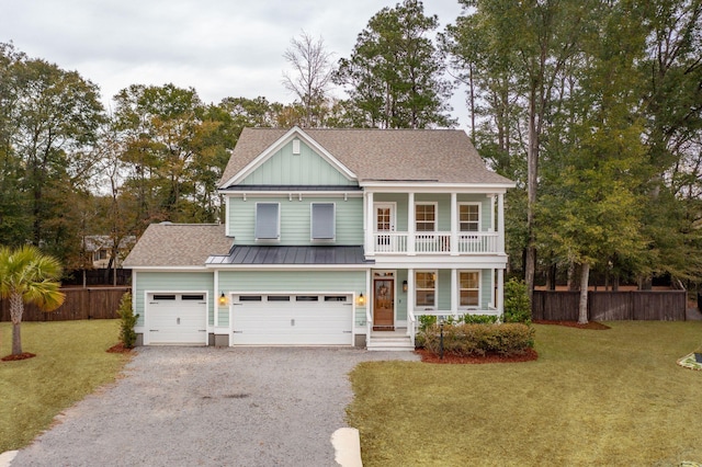 view of front of house featuring covered porch, a balcony, a garage, and a front lawn