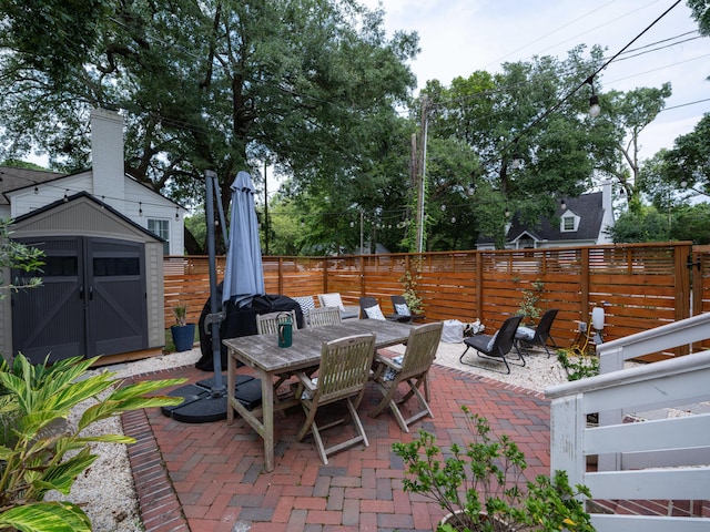2 Live Oak Ave, Charleston, SC 29407 - view of patio / terrace featuring a fenced backyard, an outdoor structure, outdoor dining area, and a shed
