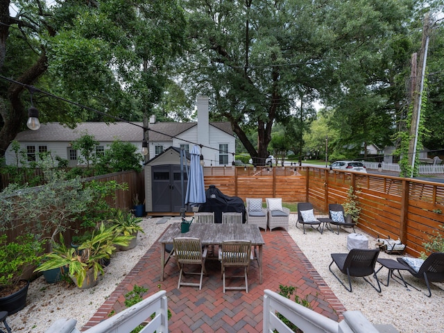 2 Live Oak Ave, Charleston, SC 29407 - view of patio / terrace with a fenced backyard, outdoor dining space, an outdoor structure, and a shed