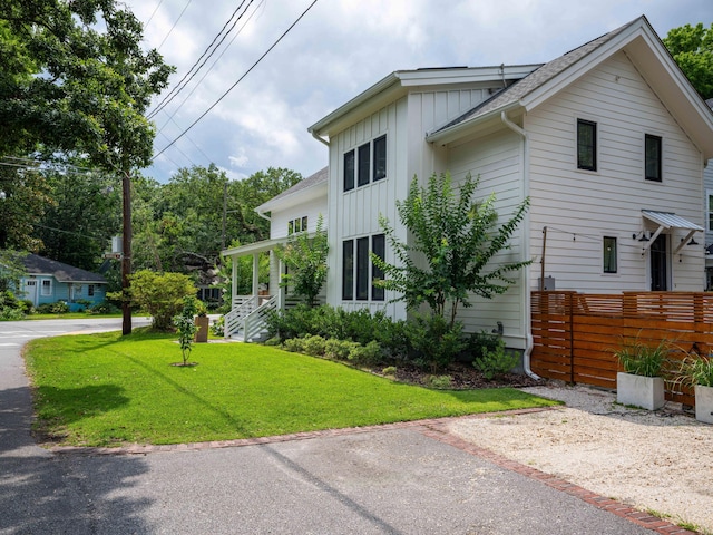 2 Live Oak Ave, Charleston, SC 29407 - view of front of house with board and batten siding, a front yard, and fence