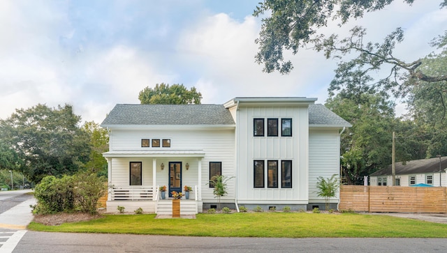 2 Live Oak Ave, Charleston, SC 29407 - modern inspired farmhouse featuring a front yard, a porch, board and batten siding, fence, and roof with shingles
