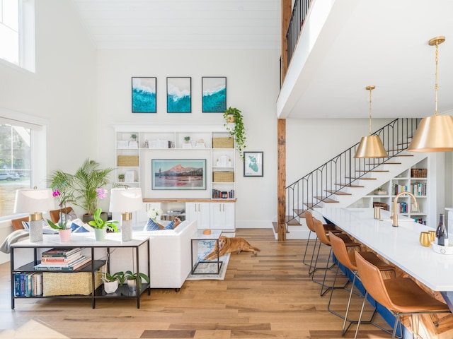 2 Live Oak Ave, Charleston, SC 29407 - living area featuring light wood-style flooring, stairway, a towering ceiling, and baseboards