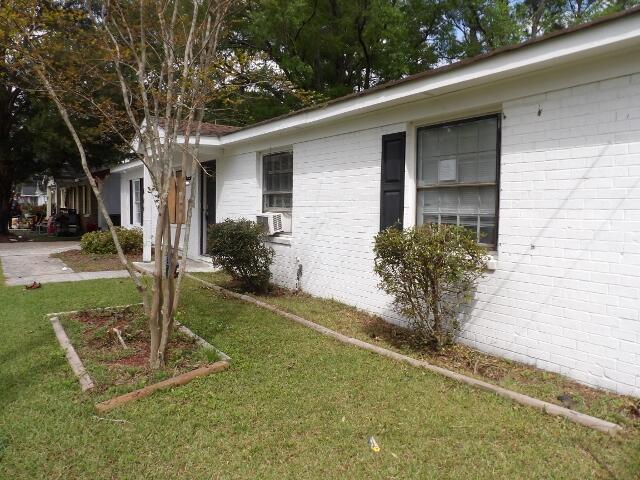 view of side of property with a lawn and brick siding