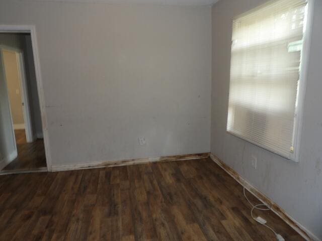 empty room featuring wood finished floors and baseboards