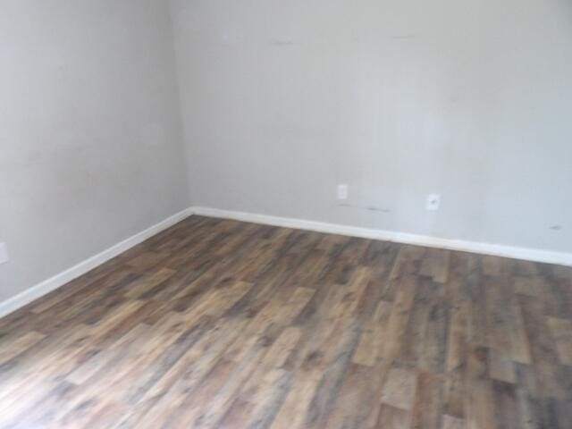 unfurnished room with baseboards and wood finished floors