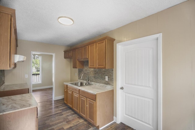 kitchen featuring backsplash, dark hardwood / wood-style flooring, a textured ceiling, and sink