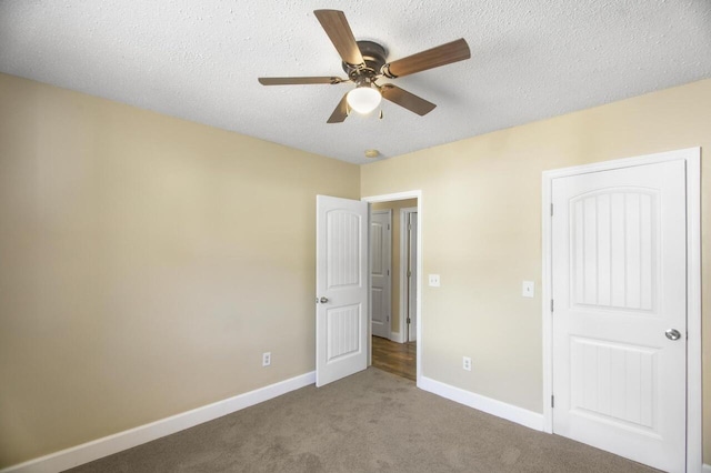 unfurnished bedroom featuring ceiling fan, light colored carpet, and a textured ceiling