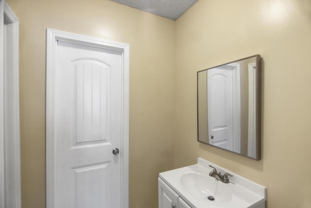 bathroom featuring a textured ceiling and vanity with extensive cabinet space