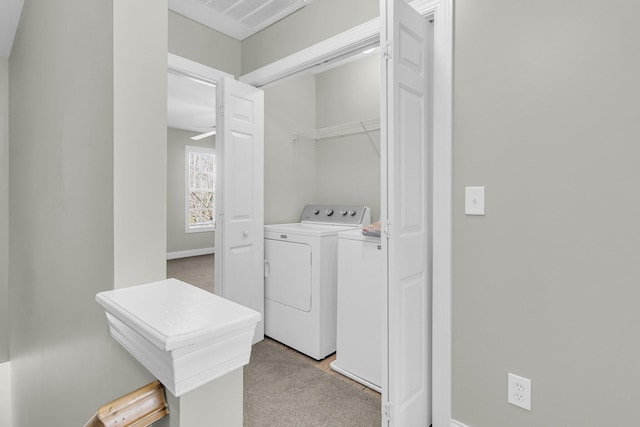 clothes washing area featuring ceiling fan, light carpet, and independent washer and dryer