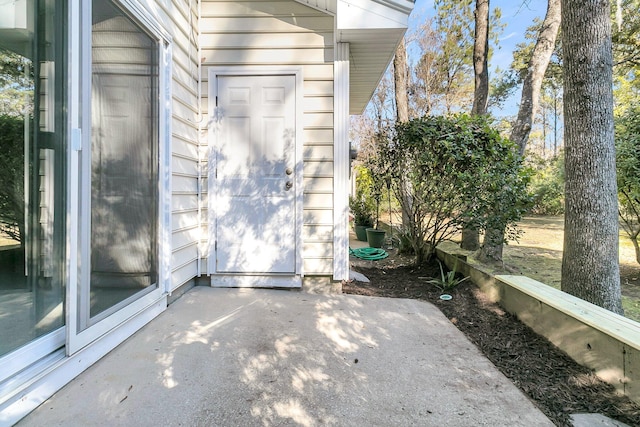 view of exterior entry with a patio area