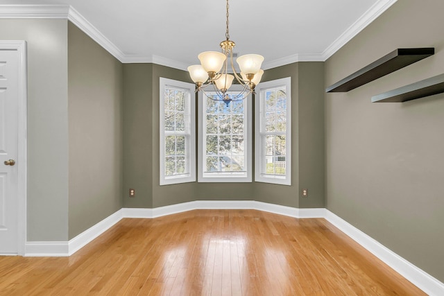 unfurnished dining area with wood-type flooring, crown molding, and a notable chandelier